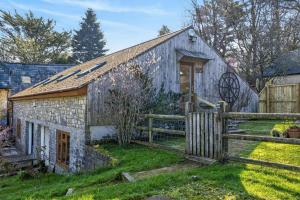 an old stone barn with a wooden fence at 2 Bed in Beaminster oc-63047 in Broadwindsor