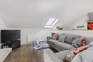 a living room with a couch and a flat screen tv at 2 Bed in Beaminster oc-63047 in Broadwindsor