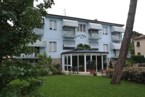 a large white building with a lawn in front of it at Hotel Riviera Blu in Tirrenia