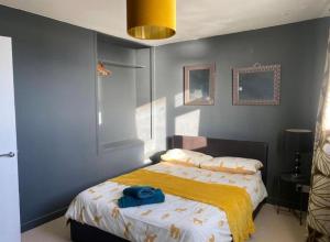 a bedroom with a bed with a yellow blanket on it at Central location Sea view in Hastings +28 photos