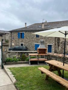 a picnic table and an umbrella in front of a building at Le Logis des Cerfs in Les Angles