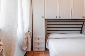 a bedroom with a bed and white cabinets at Il Posto Giusto in Costa Rei