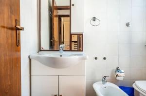 a white bathroom with a sink and a mirror at Il Posto Giusto in Costa Rei +30 photos