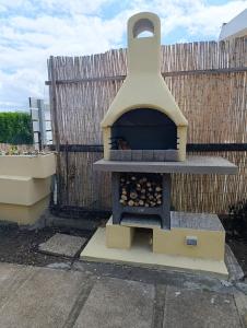a outdoor pizza oven sitting on top of a fence at Il Posto Giusto in Costa Rei