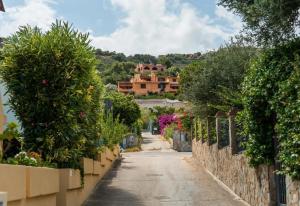an empty street with trees and a house in the background at Il Posto Giusto in Costa Rei