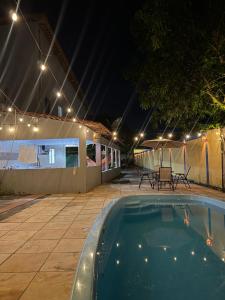 a swimming pool at night with lights above it at Professor Guest House in Santo Amaro