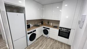 a kitchen with white cabinets and white appliances at Villamadrid Home 2 in Madrid +9 photos