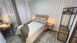 a bedroom with a bed with two tables and a mirror at Villamadrid Home 2 in Madrid