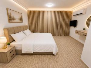a hotel room with a bed and a television at سرايا الغربية للشقق المخدومة - saraya algharbiyya Establishment in Jeddah +25 photos