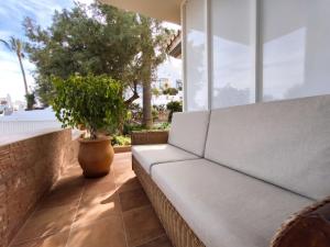 a white couch on a patio with a potted plant at Rooms Flor del Pato in Benalmádena
