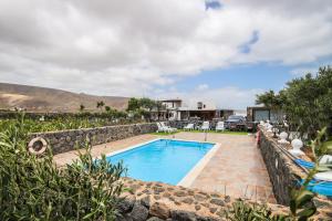 a swimming pool in a yard with a stone wall at Finca Villanueva in Mala