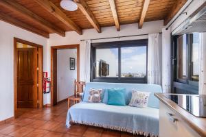 a blue couch in a room with a large window at Finca Villanueva in Mala +123 photos