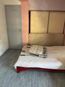 a bedroom with a bed with a white mattress and a door at Cocon de Audrey in Graulhet