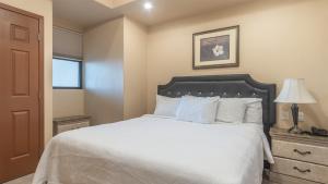 a bedroom with a white bed with a black headboard at Las Palomas Beach & Golf Resort - One Bedroom Condos in Puerto Peñasco +32 photos
