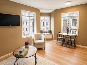 a living room with a tv and a table and chairs at Barfot Apartment - Bergen City center in Bergen