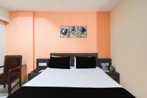 a bedroom with a bed with two paintings on the wall at Townhouse OAK Secunderabad Near Railway Station Formerly Hotel Brahma in Hyderabad +58 photos