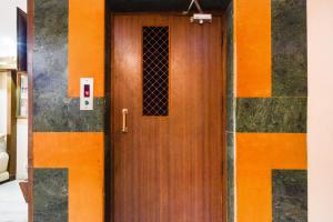 a wooden door in a building with an orange at Townhouse OAK Secunderabad Near Railway Station Formerly Hotel Brahma in Hyderabad