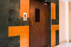 a wooden door in a room with a wall at Townhouse OAK Secunderabad Near Railway Station Formerly Hotel Brahma in Hyderabad