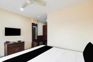 a bedroom with a bed and a flat screen tv at Townhouse OAK Secunderabad Near Railway Station Formerly Hotel Brahma in Hyderabad
