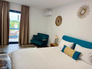 a bedroom with a bed and a blue chair at Delta Land Bungalows in Crisan +61 photos