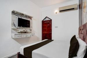 a bedroom with a bed with a red door and a tv at Hotel O Vishal Residency in New Delhi