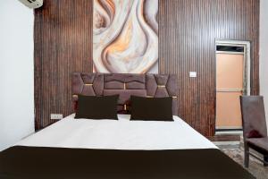a bedroom with a large bed and two chairs at Hotel O Vishal Residency in New Delhi +21 photos