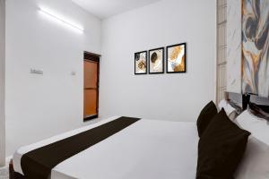 a white room with a bed and three pictures on the wall at Hotel O Vishal Residency in New Delhi