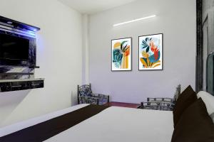 a bedroom with a bed and two pictures on the wall at Hotel O Vishal Residency in New Delhi