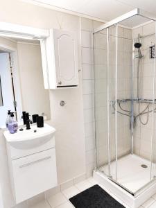 a white bathroom with a shower and a sink at Barfot Apartment - Bergen City center in Bergen +28 photos