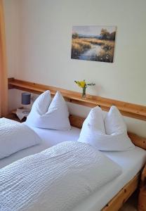 two beds with white pillows in a bedroom at Bergbauern Wirtshaus in Kötschach