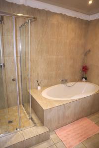 a large bathroom with a tub and a shower at Guesthouse Gabby in Klerksdorp +15 photos