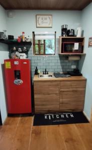 a kitchen with a red refrigerator and a sink at La Casita Verde in Boquete