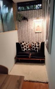 a black couch sitting in a room with a window at La Casita Verde in Boquete