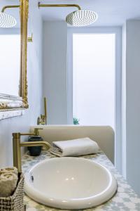 a bathroom with a white sink and a mirror at Manu's House - Refined Design, Effortless Space in Skopelos Town +36 photos