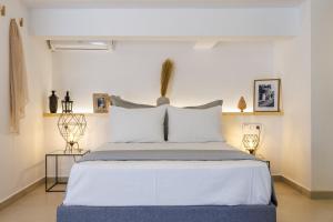 a bedroom with a large bed with white sheets and pillows at Manu's House - Refined Design, Effortless Space in Skopelos Town