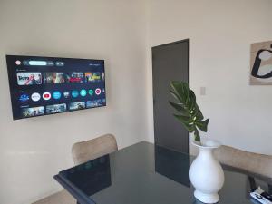 a room with a table with a vase and a tv at CM Descanso boutique in Colorado River