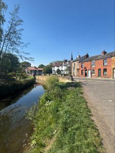 a river in a town with buildings and a street at 1 Bed Cottage Great Ayton - TOP Cottage in Great Ayton