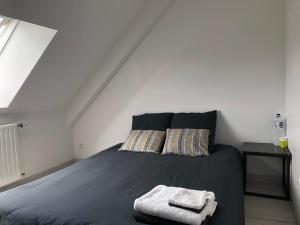 a bedroom with a bed with two towels on it at Maison 3 chambres et jardin in Le Mans
