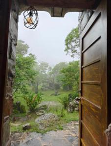 an open door with a view of a field at Cabañas el amanecer Jacala in Cuetzalán del Progreso