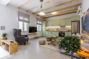 a living room with green cabinets and a couch and a table at Manu's House - Refined Design, Effortless Space in Skopelos Town