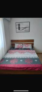 a bedroom with a bed with a red blanket at Talic Apartmani in Sutomore