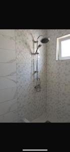 a bathroom with a shower with a glass door at Talic Apartmani in Sutomore +6 photos
