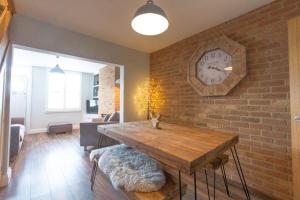 a room with a brick wall with a clock on the wall at 1 Bed Cottage Great Ayton - TOP Cottage in Great Ayton