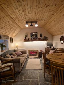 a living room with a couch and a table at Mag Byrne's Cottage in Sandy Ford