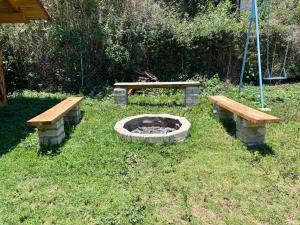two benches and a picnic table in the grass at Cabañas El Borrego in Mazamitla
