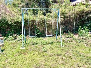 a swing set in the grass in a yard at Cabañas El Borrego in Mazamitla +2 photos