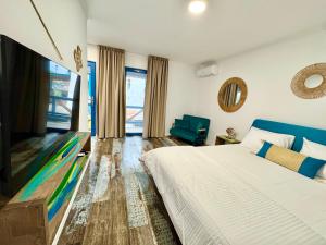 a bedroom with a bed and a flat screen tv at Delta Land Bungalows in Crisan