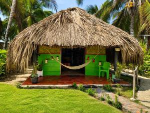 a green hut with a hammock in front of it at Antara del Mar in San Bernardo del Viento +65 photos