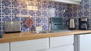 eine Küche mit Spüle und blau-weißen Fliesen in der Unterkunft taol in Vila Nova de Gaia