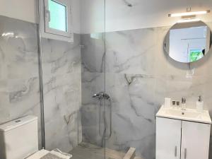 a bathroom with a shower and a toilet and a sink at Κωνσταντίνος Έλενα Studios in Pefki